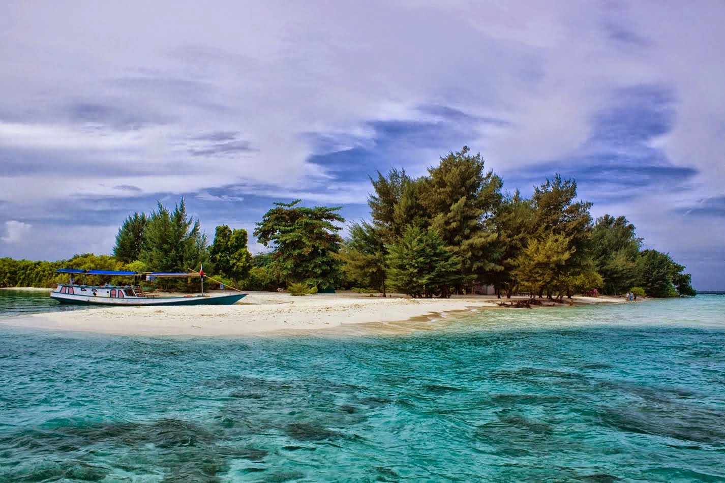 Pantai berpasir putih bersih di Kepulauan Karimunjawa dengan air laut jernih biru-toska