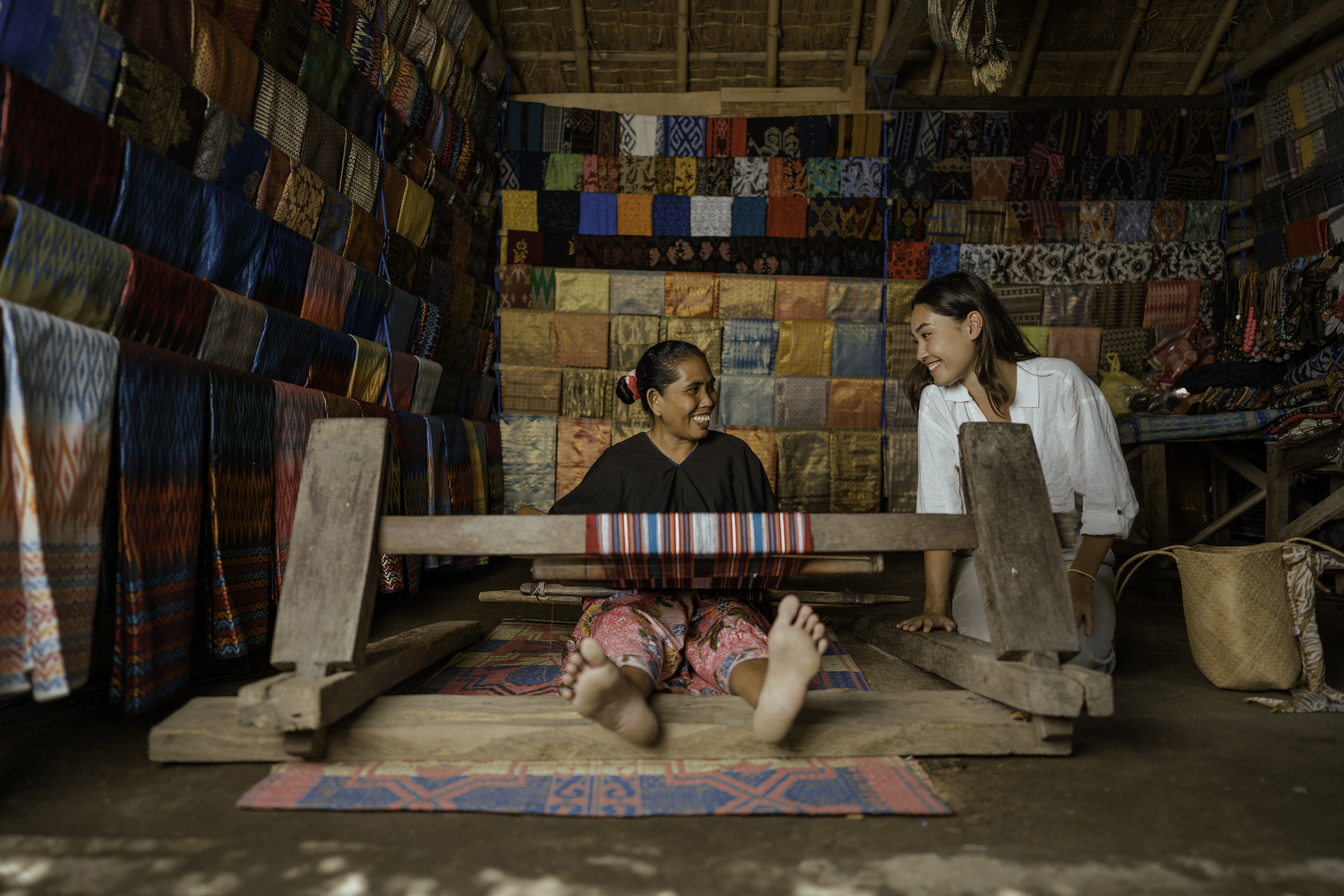 Penenun perempuan Sasak di teras rumah Bale Desa Sade Lombok mengerjakan kain tenun tradisional