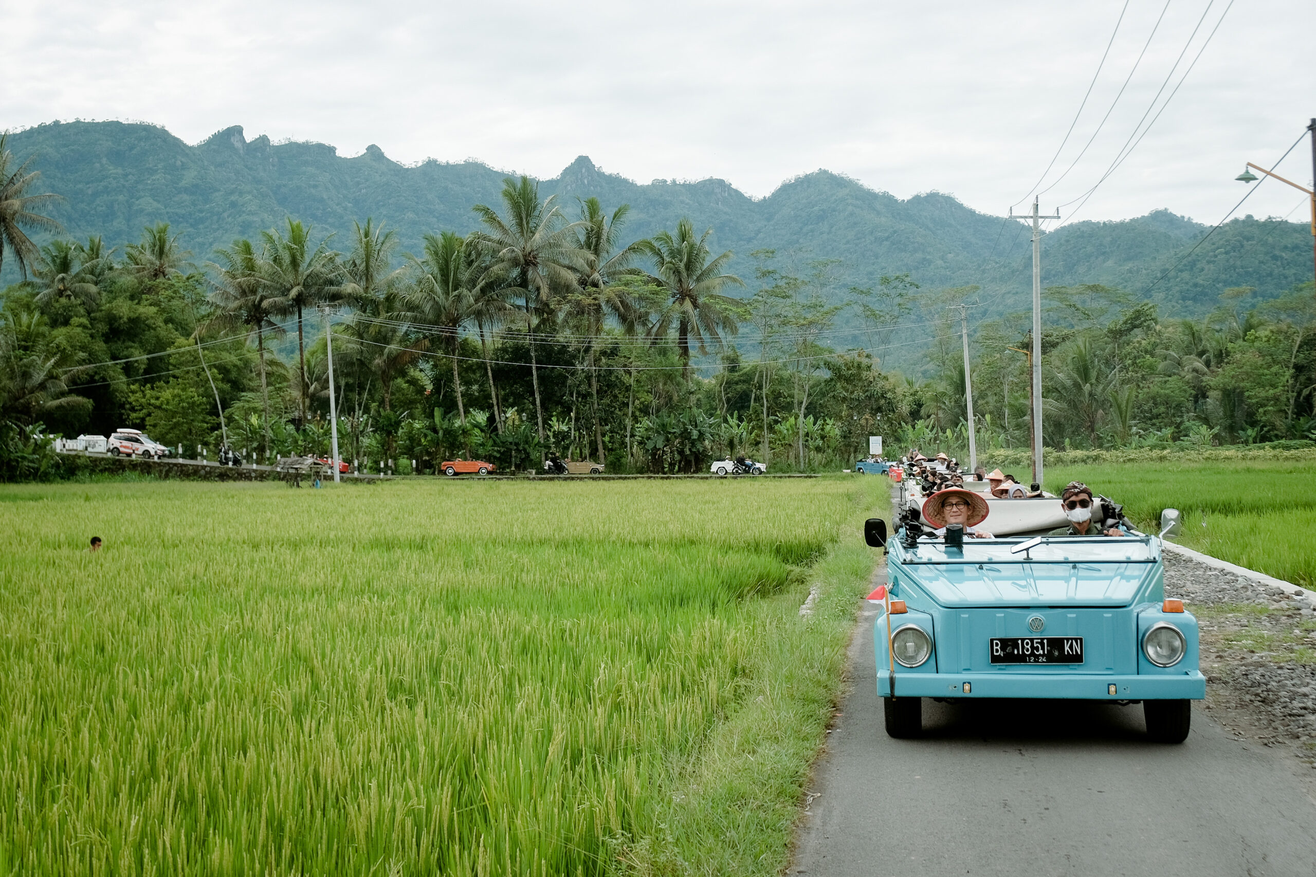 VW Safari klasik beratap terbuka menyusuri jalan desa dan persawahan di sekitar Borobudur dan Prambanan Yogyakarta